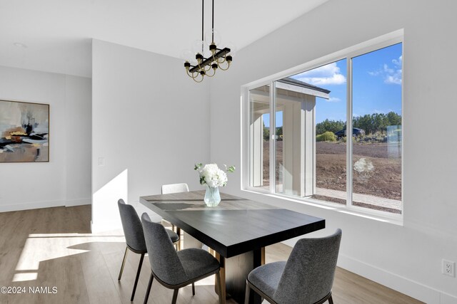 dining room featuring a notable chandelier and light wood-type flooring