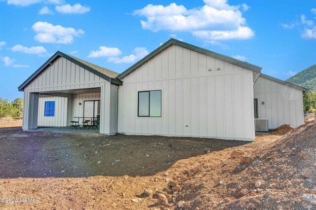 rear view of property with central AC