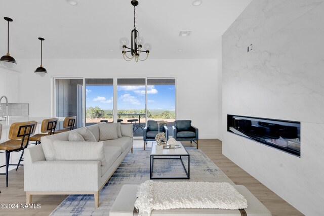 living room with a chandelier and light wood-type flooring