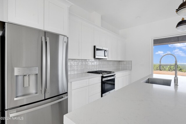 kitchen featuring sink, stainless steel appliances, white cabinets, and tasteful backsplash