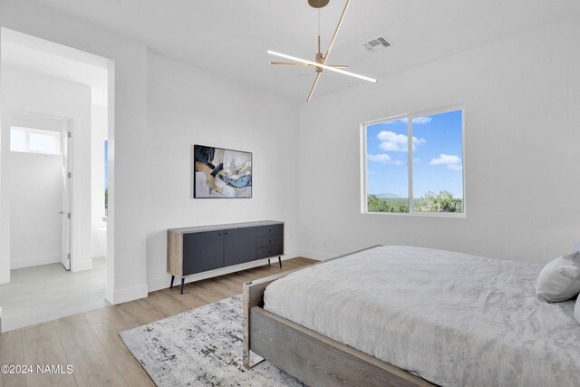 bedroom featuring light hardwood / wood-style flooring and ensuite bath