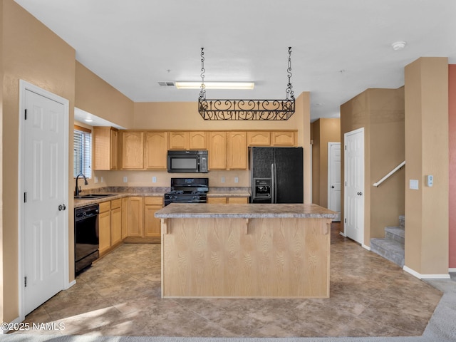 kitchen featuring black appliances, light brown cabinets, a kitchen island, and light countertops