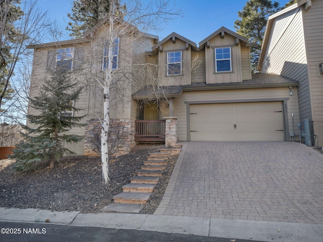 view of front of home with board and batten siding, decorative driveway, and an attached garage