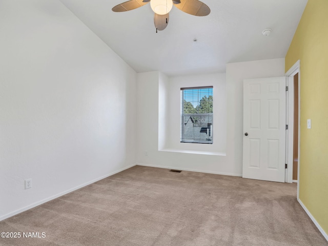 spare room featuring light carpet, baseboards, visible vents, and a ceiling fan