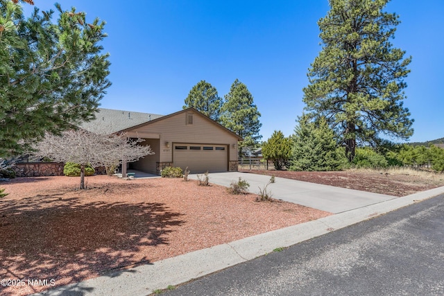 view of front of house with fence, concrete driveway, and an attached garage