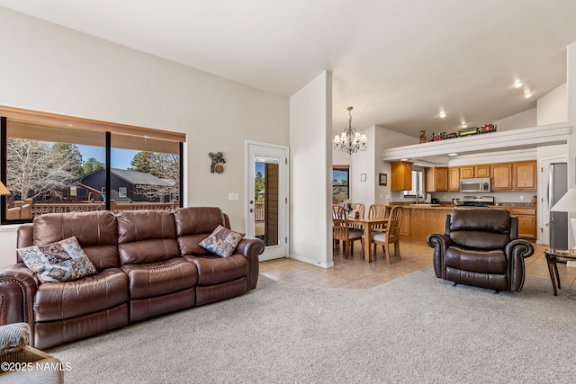 living room featuring light tile patterned floors, a notable chandelier, high vaulted ceiling, and light carpet
