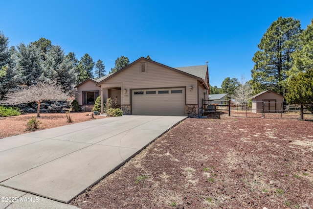 ranch-style home with concrete driveway, stone siding, a garage, and fence