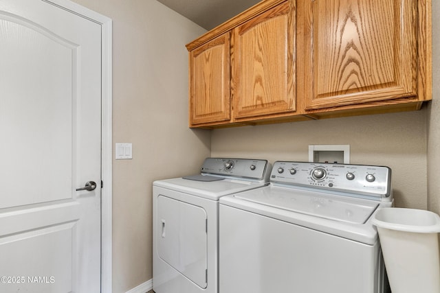 washroom featuring a sink, washing machine and dryer, and cabinet space