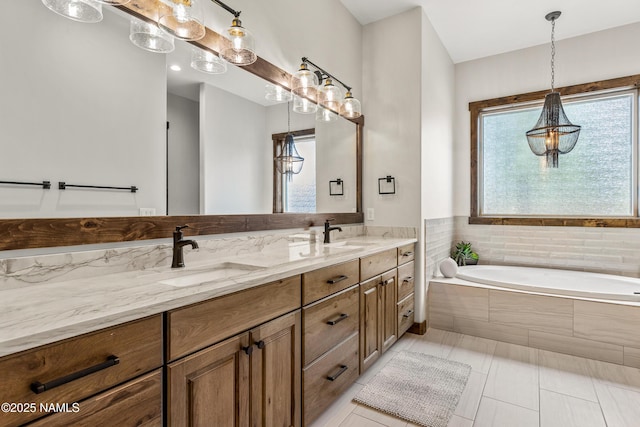 bathroom with tiled tub, vanity, a wealth of natural light, and tile patterned floors