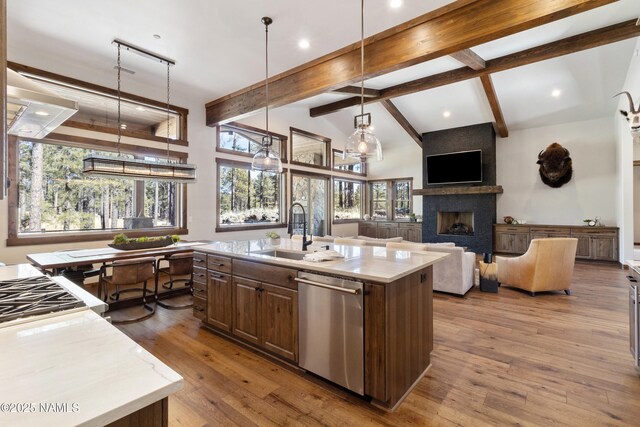 unfurnished bedroom with lofted ceiling with beams, connected bathroom, a large fireplace, and light carpet