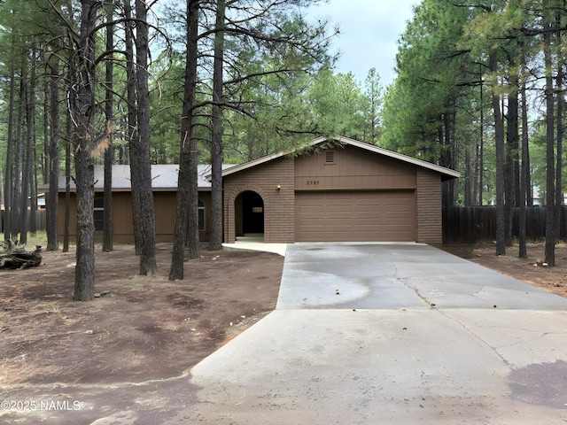 2787 N Pebble Beach Dr, Flagstaff, AZ 86004 - view of front of house featuring concrete driveway, an attached garage, and brick siding