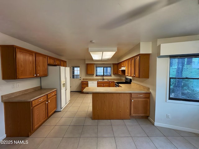 2787 N Pebble Beach Dr, Flagstaff, AZ 86004 - kitchen featuring white appliances, a sink, a peninsula, brown cabinetry, and light tile patterned flooring
