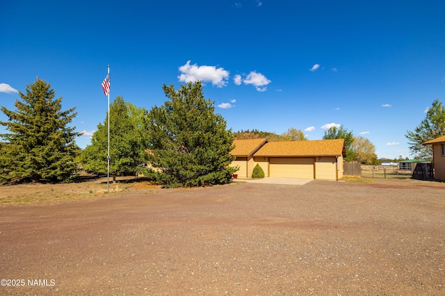 6120 E Treadway Trl, Flagstaff, AZ 86004 - view of front of home featuring fence, a garage, and dirt driveway