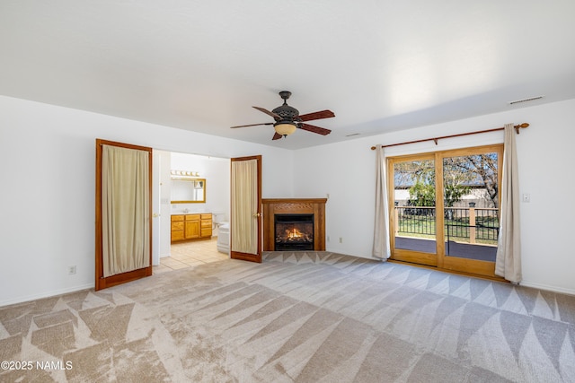 6120 E Treadway Trl, Flagstaff, AZ 86004 - unfurnished living room featuring light colored carpet, a ceiling fan, a warm lit fireplace, and baseboards