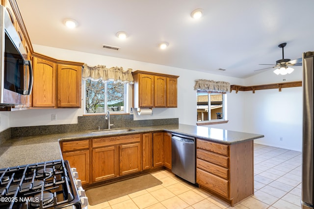 6120 E Treadway Trl, Flagstaff, AZ 86004 - kitchen featuring appliances with stainless steel finishes, a sink, a peninsula, brown cabinets, and lofted ceiling