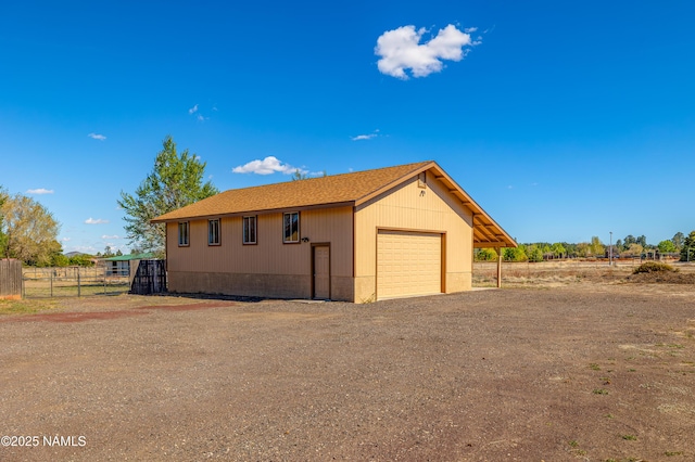 6120 E Treadway Trl, Flagstaff, AZ 86004 - view of side of property with a detached garage, fence, driveway, and a shingled roof