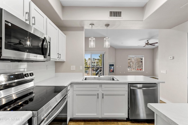 4343 E Soliere Ave Unit 2068, Flagstaff, AZ 86004 - kitchen with visible vents, a peninsula, a sink, stainless steel appliances, and light countertops
