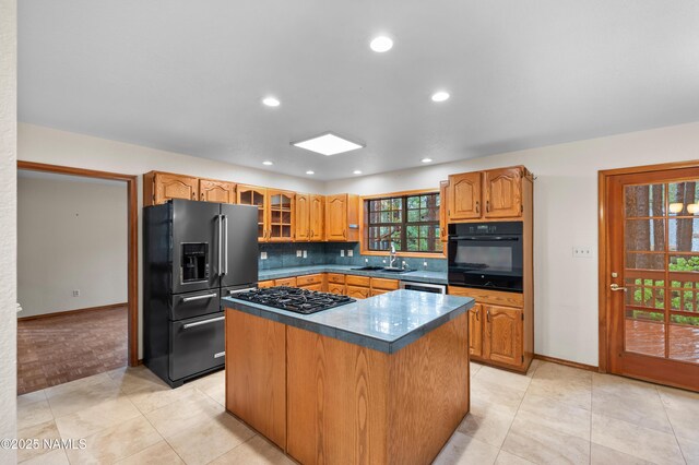 3130 Tina Ln, Flagstaff, AZ 86001 - kitchen with black appliances, a center island, tasteful backsplash, glass insert cabinets, and dark countertops