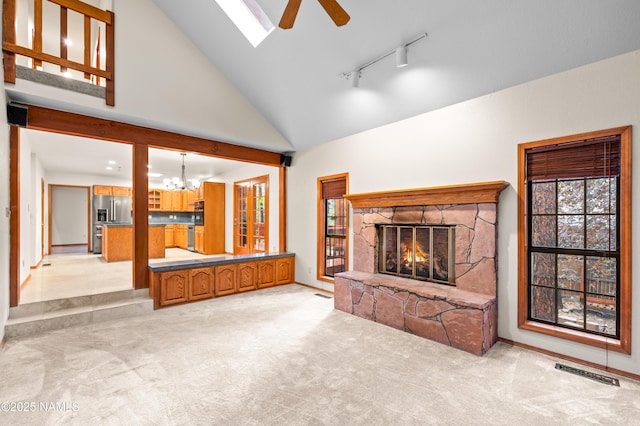 3130 Tina Ln, Flagstaff, AZ 86001 - unfurnished living room featuring ceiling fan, a stone fireplace, a chandelier, high vaulted ceiling, and light carpet