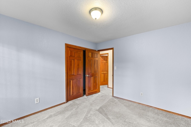 3130 Tina Ln, Flagstaff, AZ 86001 - unfurnished bedroom with a closet, light carpet, and a textured ceiling