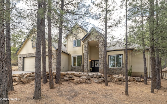 4276 E Coburn Dr, Flagstaff, AZ 86004 - view of front of property featuring stone siding, an attached garage, and concrete driveway