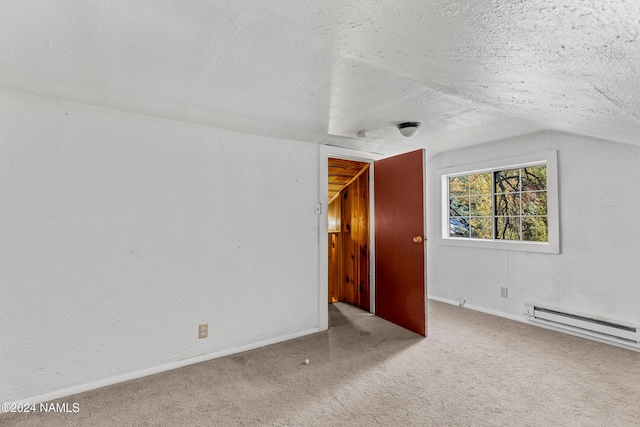 additional living space featuring vaulted ceiling, baseboard heating, a textured ceiling, and carpet floors