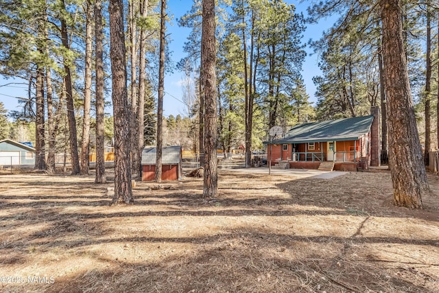 view of yard with covered porch and a storage shed