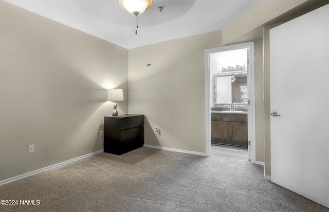 unfurnished bedroom with ceiling fan, sink, and light carpet