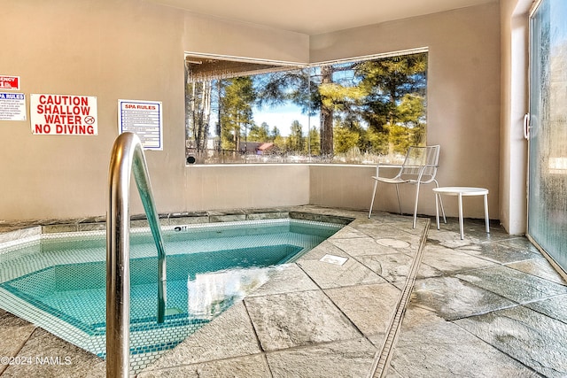 view of swimming pool with a hot tub