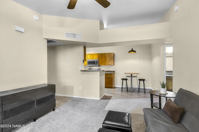 carpeted living room with a towering ceiling and ceiling fan