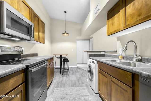 kitchen with washer / dryer, white dishwasher, sink, pendant lighting, and electric stove