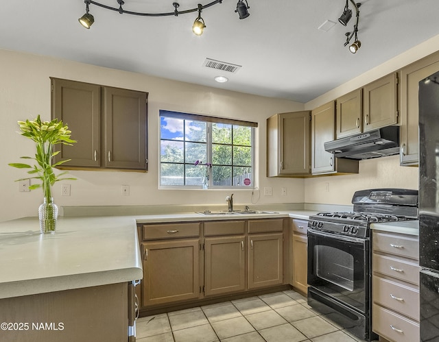 4100 E Village Cir, Flagstaff, AZ 86004 - kitchen featuring black gas stove, under cabinet range hood, light tile patterned floors, and light countertops