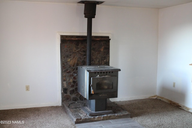 room details featuring a wood stove and carpet flooring