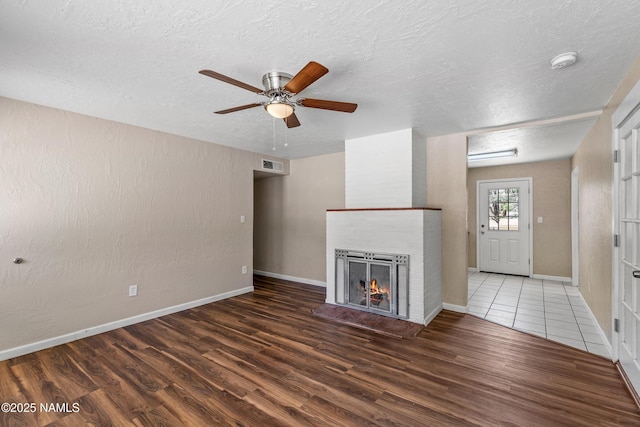 2603 E Lockett Rd, Flagstaff, AZ 86004 - unfurnished living room featuring a textured ceiling, ceiling fan, wood finished floors, and visible vents