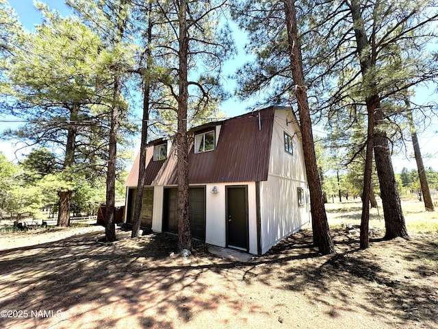 99 N Scenic Loop Trl, Williams, AZ 86046 - view of property exterior featuring a gambrel roof, a garage, driveway, and an outbuilding