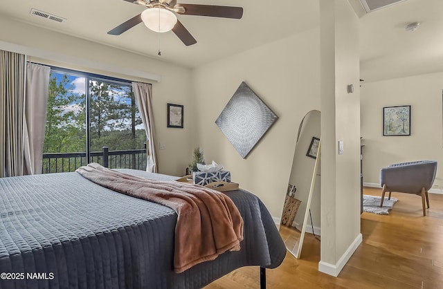 2929 Kletha Trl, Flagstaff, AZ 86005 - bedroom with access to outside, wood finished floors, baseboards, arched walkways, and a ceiling fan