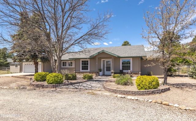 8210 Winchester Dr, Flagstaff, AZ 86004 - ranch-style home with driveway, a garage, stone siding, fence, and a shingled roof