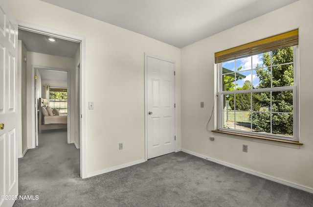 8210 Winchester Dr, Flagstaff, AZ 86004 - unfurnished bedroom with carpet floors, multiple windows, and baseboards
