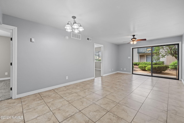 tiled spare room featuring ceiling fan with notable chandelier and plenty of natural light