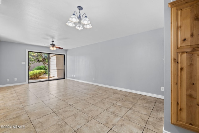 empty room featuring ceiling fan with notable chandelier and light tile patterned floors