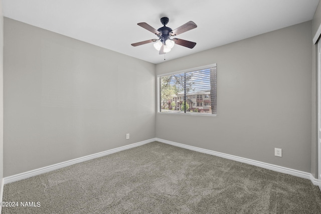 carpeted spare room featuring ceiling fan