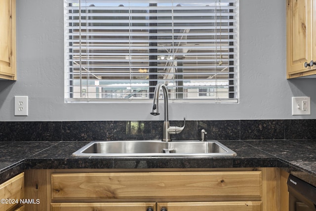 kitchen with sink, light brown cabinetry, and black dishwasher