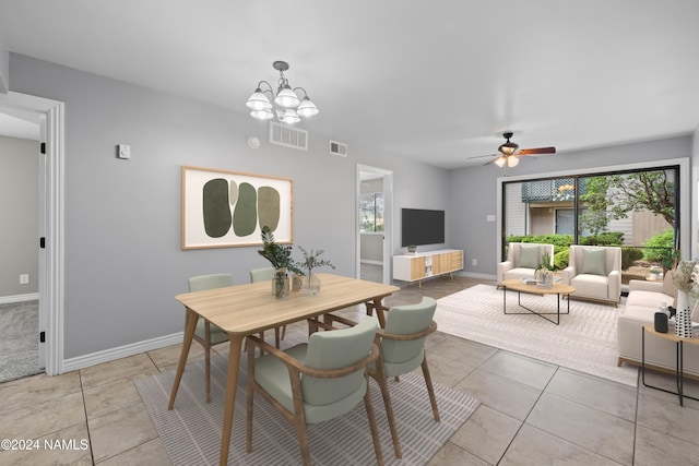 dining area with ceiling fan with notable chandelier and light tile patterned flooring