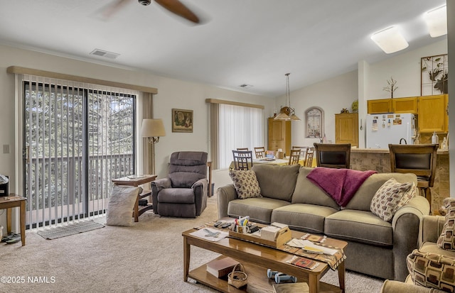 carpeted living area featuring ceiling fan, vaulted ceiling, and visible vents
