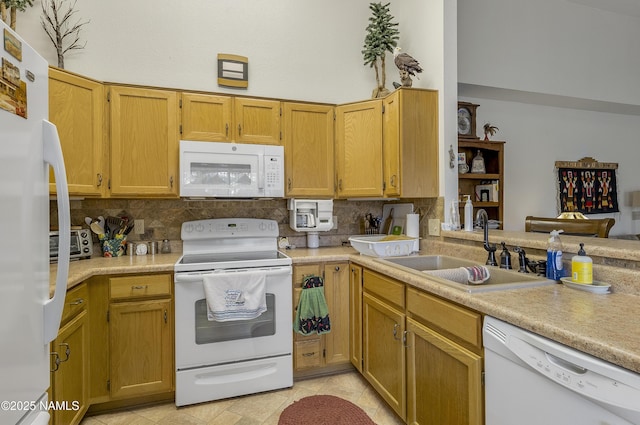 kitchen featuring white appliances, backsplash, a sink, and light countertops