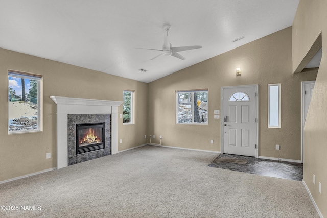 foyer entrance with ceiling fan, a fireplace, visible vents, vaulted ceiling, and carpet flooring