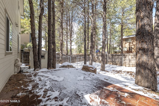 yard covered in snow featuring an outdoor structure and fence