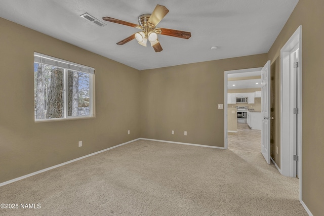 empty room with visible vents, ceiling fan, light carpet, and baseboards
