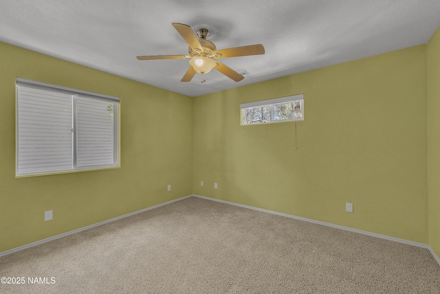 carpeted spare room with baseboards and a ceiling fan