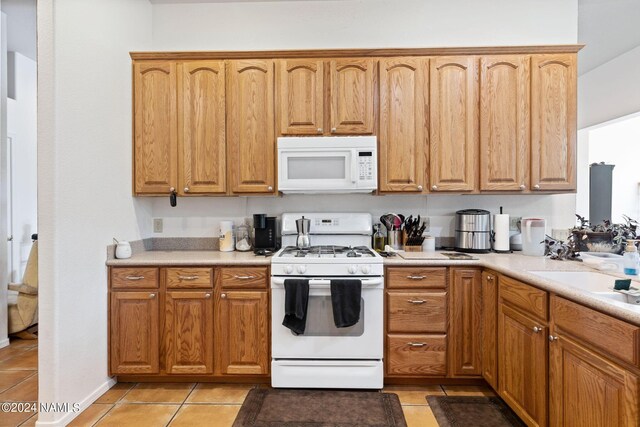 kitchen featuring white appliances and light tile patterned floors